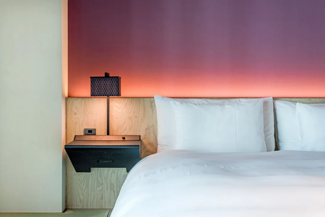 Hotel bedroom with white bedding and soft lighting