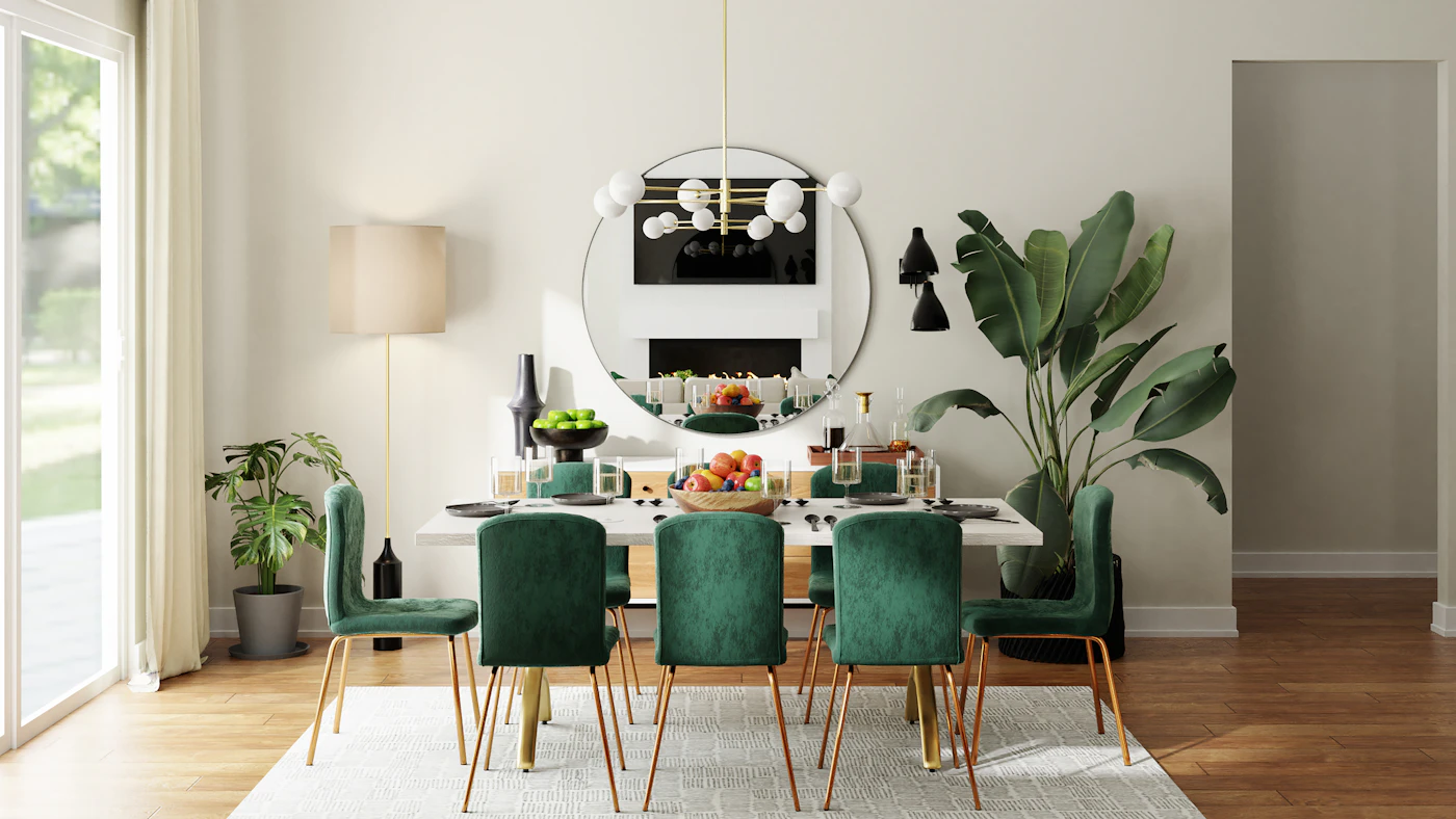 A dining table with green upholstered chairs and a round wall mirror.
