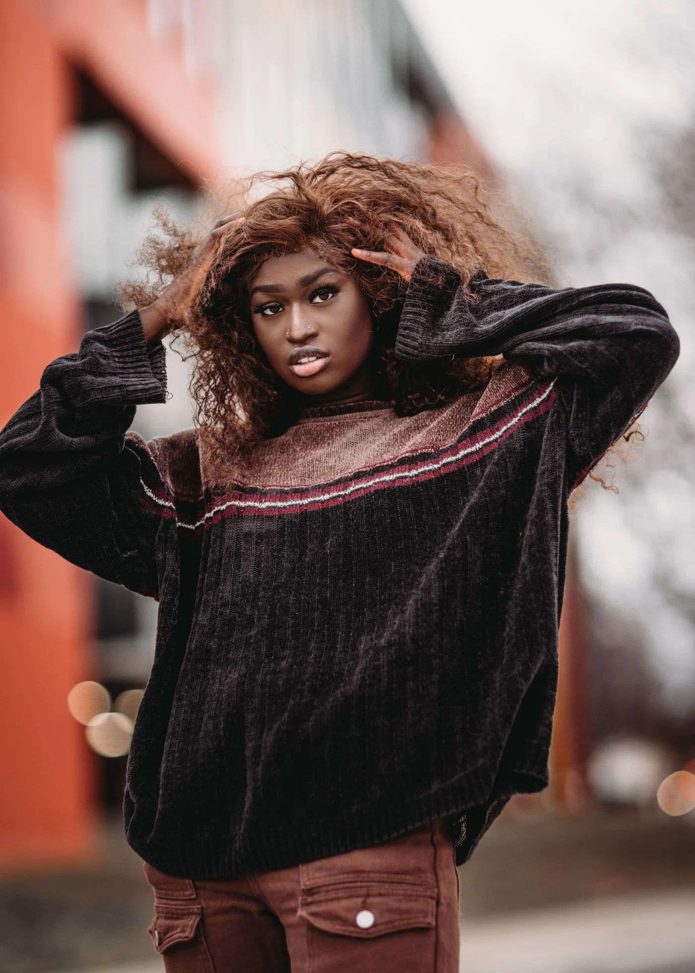 A person wearing a dark textured top on an urban street.